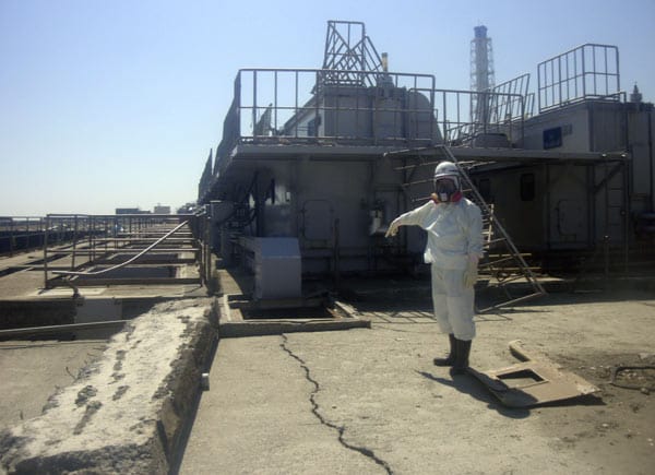 Ein Arbeiter in Fukushima deutet auf einen vom Erdbeben verursachten Riss im Boden, der erst jetzt entdeckt wurde. Es wird vermutet, dass stark verstrahltes Wasser durch Risse im Boden ins Meer gesickert ist und die extrem hohe Strahlung des Meerwassers verursacht hat.