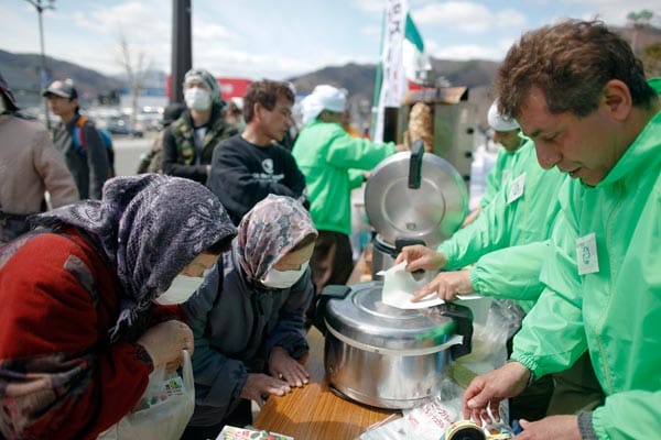 Einheimische verbeugen sich dankbar für eine kostenlose Essensausgabe von in Kamaishi lebenden Iranern.