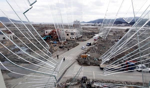 Blick durch eine zersprungene Fensterscheibe auf das zerstörte Rikuzentakata.