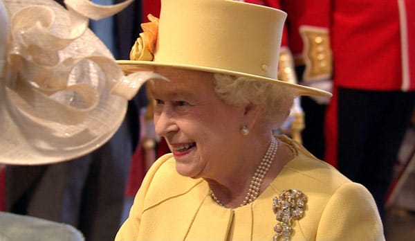 Die Queen kommt in einem sonnengelben Kostüm.