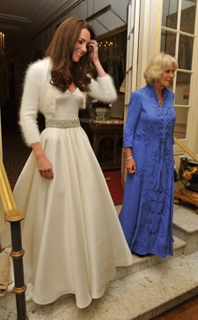 In diesem Kleid von von Alexander-McQueen-Designerin Sarah Burton kam Kate zur Hochzeitsparty im Bukingham Palast, zu der 300 Gäste geladen waren. Neben ihr: Charles' Gattin Camilla, die sich in ein langes blaues Kleid hüllte.