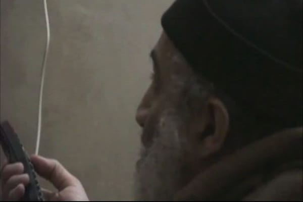 Auf den tonlosen Aufnahmen ist ein alternder Top-Terrorist mit grauem Haar und Bart zu sehen, der sich selbst in den Nachrichten betrachtet.