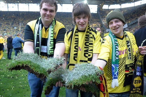 Dortmunder Fans rasen auf den Rasen, um sich den heiligen Rasen zu sichern.