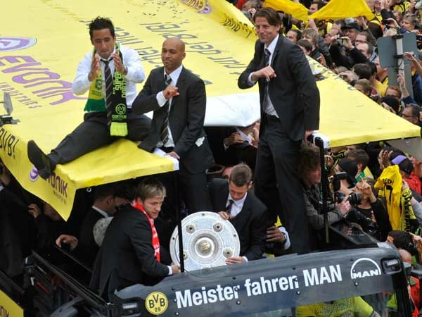Lucas Barrios (v. li.), Dede und Roman Weidenfeller haben es sich auf dem Dach gemütlich gemacht. Jakub Blasczykowski (mit rotem Schal) bewacht die Meisterschale. Lucas Barrios (v. li.), Dede und Roman Weidenfeller haben es sich auf dem Dach gemütlich gemacht. Jakub Blasczykowski (mit rotem Schal) bewacht die Meisterschale.