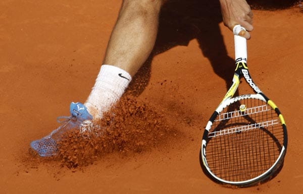 Rafael Nadal wirbelt mächtig Sand auf.