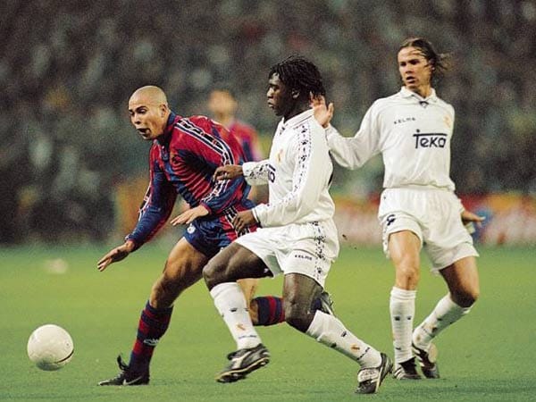 Von 1996 bis 1997 trug Ronaldo (li.) das Trikot des FC Barcelona. Er kam für 30 Millionen DM aus Eindhoven. Auch wenn es ihn nur ein Jahr bei den Katalanen hielt, war er dort sehr erfolgreich: So schoss er im Finale des Europapokals der Pokalsieger das entscheidende 1:0 gegen den Titelverteidiger Paris Saint-Germain und wurde mit 34 Treffern der Torschützenkönig in der Primera División. Hier versucht er, sich gegen die Madrilenen Clarence Seedorf (Mitte) und Fernando Redondo durchzusetzen.