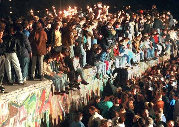 Das Ende des "Antifaschistischen Schutzwalls": Das Bild vom 11.11.1989 zeigt jubelnde Menschen, die mit Wunderkerzen auf der Berliner Mauer sitzen. Nach der Öffnung eines Teils der deutsch-deutschen Grenzübergänge in der Nacht vom 9. auf den 10. November 1989 reisen Millionen DDR-Bürger für einen kurzen Besuch in den Westen.