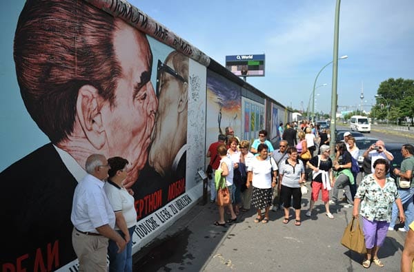 Heute lassen sich Touristen an der "East Side Gallery" fotografieren. Es ist mit 1300 Metern das längste verbliebene Stück der Mauer in Berlin-Friedrichshain, auf dem sich 118 Künstler ausgelebt haben.