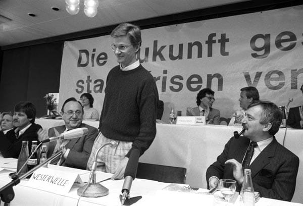 Guido Westerwelle auf einen Bundeskongress der Jungen Liberalen 1986 in Osnabrück. Links neben ihm sitzt der damalige Außenminister Hans-Dietrich Genscher, dessen Amt Westerwelle 25 Jahre später im zweiten Kabinett Merkel übernehmen wird.