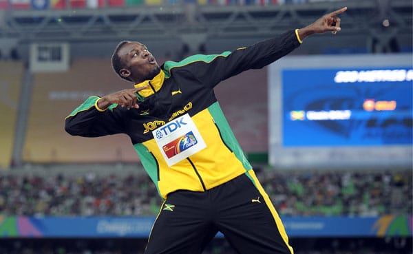 Supermann und Superstar Usain Bolt gestikuliert auf dem Siegerpodest.