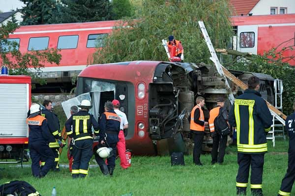 Der vordere von vier Waggons ist auf ein Feld gekippt.