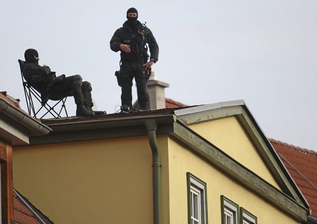 Der Papstbesuch findet unter strengen Sicherheitskontrollen statt. In der thüringischen Hauptstadt Erfurt halten Polizisten auf einem Hausdach die Stellung