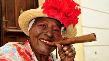 In der kubanischen Hauptstadt Havanna genießt man das Leben. Diese Frau lässt sich beim Rauchen einer riesigen Zigarre fotografieren.