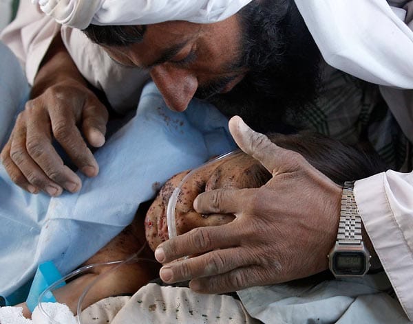 Ein afghanischer Mann wischt seinem Sohn auf dem Krankenbett eine Träne aus dem Gesicht. Politische Stabilität in Afghanistan ist noch nicht in Sicht. Dennoch kündigten die Amerikaner bis 2014 einen Truppenabzug an.