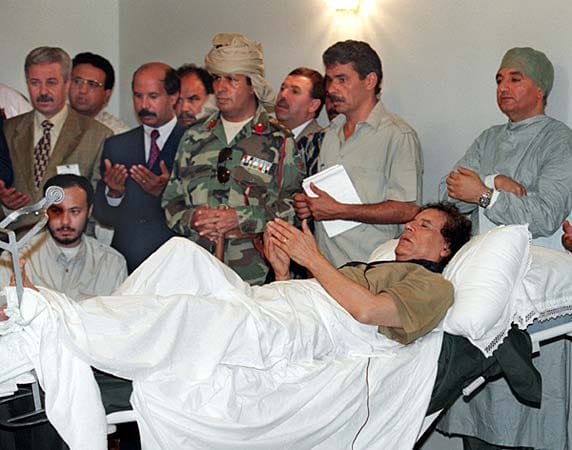 Mit den Jahren wurde Gaddafi immer neurotischer und aufbrausender. Er misstraute fast jedem. Das Bild zeigt ihn im Juli 1998, als er nach einem Sportunfall mit Freunden und Bodyguards vom Krankenbett aus betet.