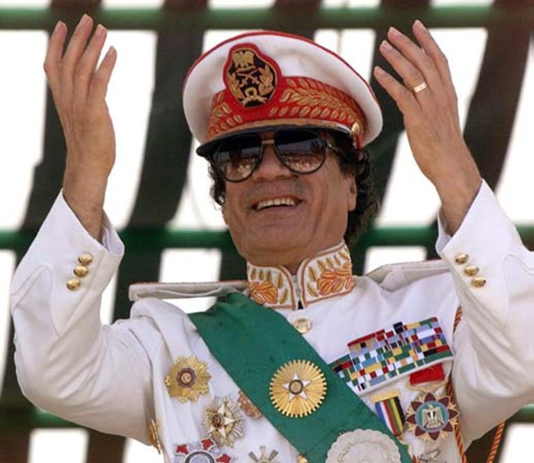 Gaddafi bei einer Militärparade in Tripolis 1999. Theaterreife Auftritte und skurrile Outfits brachten ihm den Ruf des Exzentrikers ein. Zum 40. Jahrestag der Revolution ließ er für mehrere Millionen Dollar ein bombastisches Fest inszenieren - inklusive Reitershow, Militärmärschen, Feuerwerken und Exekutionsszenen.
