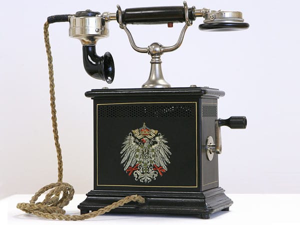 Ein historischer Tischapparat OB-05 aus dem Jahr 1906, die Abkürzung OB steht für Ortsbatterie. Die frühen Telefone hatten keine Wählscheibe, sondern einen Kurbelinduktor um sich beim Fräulein vom Amt bemerkbar zu machen. Von dort wurde der Teilnehmer mit seinem Gesprächspartner verbunden.