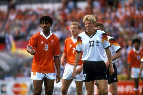 1992 das nächste große Treffen der beiden Erzrivalen: Anlass ist die Gruppenphase der EM in Schweden. Auch "Lama" Rijkaard (Nummer 8) ist wieder dabei, konzentriert sich am 18. Juni 1992 aber aufs Fußballspielen - und trifft per Kopf sehenswert zum 1:0. Der Europameister spielt Effe, Helmer und Co. schwindelig. Und als die DFB-Elf nach Jürgen Klinsmanns Anschlusstor wieder Hoffnung schöpft, beendet diese Dennis Bergkamp (Nummer 7) mit dem 3:1-Endstand. Ins Endspiel aber kommt Deutschland.