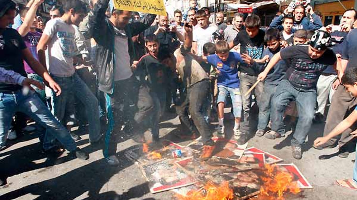 Solidarität mit den unterdrückten Demonstranten in Syrien zeigen diese Protestler im Libanon, die Bilder von Syriens Präsident Al-Assad verbrennen.