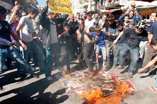 Solidarität mit den unterdrückten Demonstranten in Syrien zeigen diese Protestler im Libanon, die Bilder von Syriens Präsident Al-Assad verbrennen.