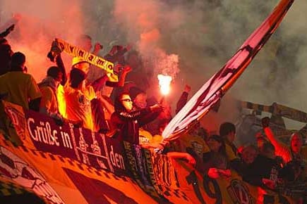 Fans von Dynamo Dresden zünden Bengalos beim Pokalspiel in Dortmund.