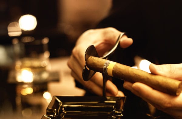 Ein perfekter Anschnitt sollte 3/4 der Größe des Zigarrendurchmessers haben und mit einem Cutter (Guillotine) oder, wie hier im Bild zu sehen, mit einer Zigarrenschere ausgeführt werden.