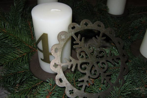 Stecken Sie Ihren weihnachtlichen Schmuck einfach mit Tannenzweigen und Kerzen zu einem Gesteck zusammen. .