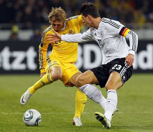 Der Ukrainer Bogdan Butko (li.) schirmt den Ball gegen den deutschen Torjäger und Kapitän Mario Gomez ab.