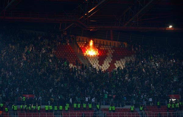 Nach dem Schlusspfiff setzen Sporting-Fans Sitzschalen des Gästeblocks in Brand. Drumherum tausende von Zuschauern.