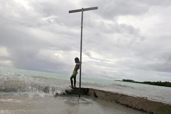 Wasser spült auf der Pazifikinsel Kiribati über die Mauern, die frühere Bewohner gegen die Erosion durch die Wellen errichtet haben. Durch den Klimawandel steigt der Meeresspiegel dramatisch an.