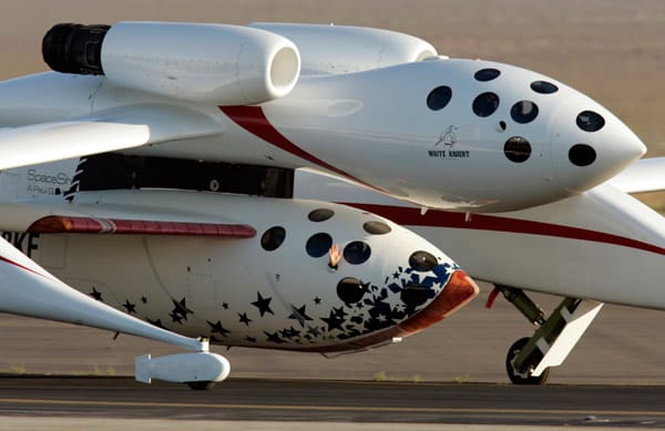 "SpaceShipOne"-Pilot Michael Melvill winkt kurz vor seinem Flug in den Orbit. Oben ist das Mutterschiff "WhiteKnight" zu sehen, an dem das Raumfahrzeug angedockt ist.