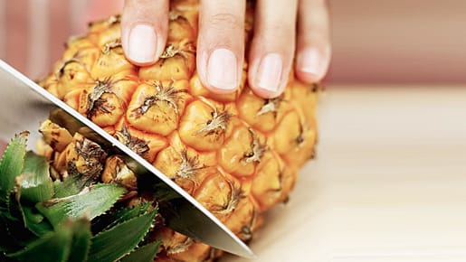 Eine Ananas wird aufgeschnitten.