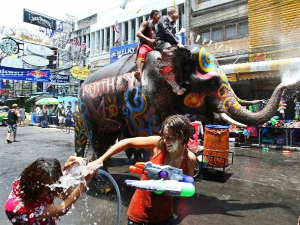 Selbst Touristen entkommen den Songkran-Ritualen nicht und mischen bei Wasserschlachten einfach mit.