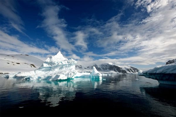 Faszination Antarktis: Die besonders stark komprimierten Teile der ansonsten weißen Eisberge leuchten beim ersten Sonnenstrahl in den unterschiedlichsten Blautönen.