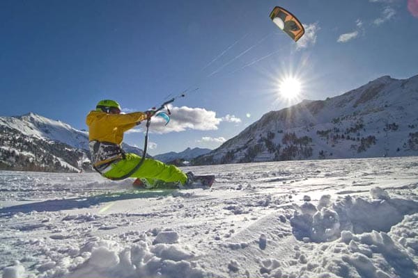 Snowkiten gilt als der neue Trend. Ein Lenkdrachen beschleunigt die Sportler auf Geschwindigkeiten bis zu 100 km/h.