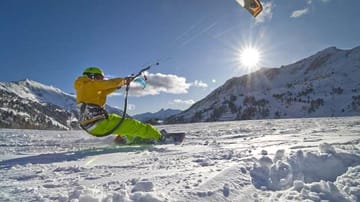 Snowkiten gilt als der neue Trend. Ein Lenkdrachen beschleunigt die Sportler auf Geschwindigkeiten bis zu 100 km/h.