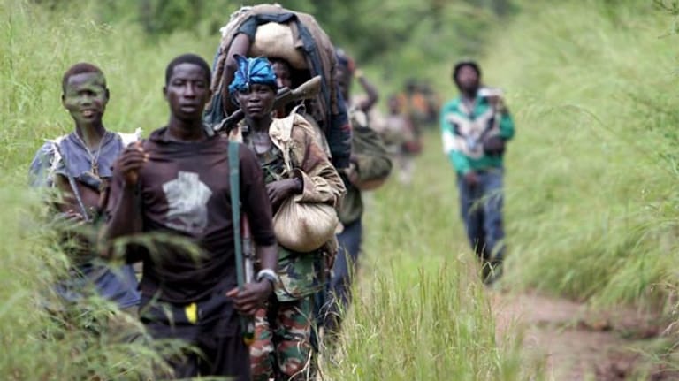 Diese Aufnahme zeigt Kämpfer der LRA auf dem Weg zu einem Lager im Südsudan (2006). Konys Truppen - Männer, Frauen, Kinder - bewegen sich über Landesgrenzen hinweg im teils dichten Urwald und sind daher extrem schwer aufzuspüren.