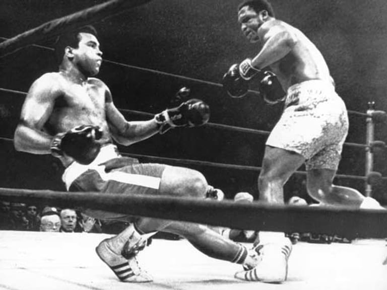Bittere Niederlage: Muhammad Ali (li.) geht am 08.03.1971 in New York im Madison Square Garden nach einem Kopftreffer durch seinen Kontrahenten und Landsmann Joe Frazier in der 15. Runde zu Boden.