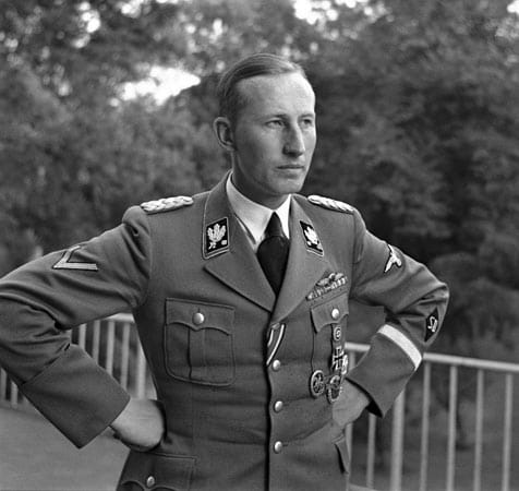 Eingeladen hat SS-Obergruppenführer Reinhard Heydrich, Chef des Sicherheitshauptamtes, Mitarbeiter von Heinrich Himmler und eine der grausamsten Führungspersonen im NS-Regime. Herman Göring hatte ihn im Juli 1941 mit der Gesamtplanung für die sogenannte "Endlösung der Judenfrage" beauftragt. 1942 stirbt Heydrich in Prag an den Folgen eines Attentats durch tschechische Widerstandskämpfer. Zur Vergeltung für seinen Tod macht die SS das Dorf Lidice dem Erdboden gleich und tötet alle Bewohner.