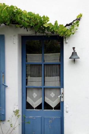 Blaue Türen und Fenster mit handgewebten Vorhängen sind typisch für die Insel.