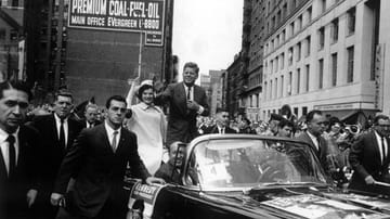 John Fitzgerald "Jack" Kennedy, geboren am 29. Mai 1917, fährt im Oktober 1960 als demokratischer Kandidat für die US-Präsidentschaftswahl am 8. November mit seiner Frau Jacqueline durch die Straßen von New York. Kennedy gewinnt die Wahl und wird am 20. Januar 1961 als 35. Präsident der USA vereidigt.