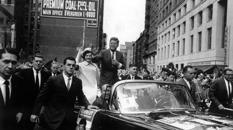 John Fitzgerald "Jack" Kennedy, geboren am 29. Mai 1917, fährt im Oktober 1960 als demokratischer Kandidat für die US-Präsidentschaftswahl am 8. November mit seiner Frau Jacqueline durch die Straßen von New York. Kennedy gewinnt die Wahl und wird am 20. Januar 1961 als 35. Präsident der USA vereidigt.