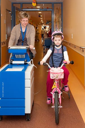 Auch beim Fahrradfahren im Krankenhausflur ist das 100 Kilo schwere Kunstherz dabei.
