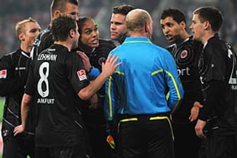 Frankfurts Spieler bedrängen Schiedsrichter Felix Brych und seinen Assistenten.