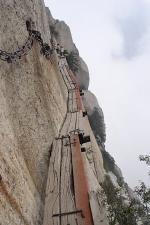 Achtung Herzinfarkt-Gefahr! Nur 30 Zentimeter breite, halbmorsche Holzbalken - mehr schlecht als recht zusammengenagelt - führen in 1000 Metern Höhe an der Felswand entlang, beim Abgrund-Wandern im Huashan-Gebirge in China.