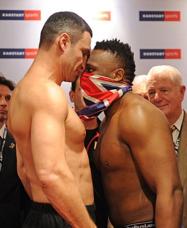 Maskiert wie ein britischer Bandit, der den Raub des WBC-WM-Gürtels plant, tritt Chisora (rechts) Klitschko in München entgegen - und drückt ihm seine Stirn ins Gesicht.