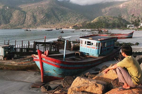 Ein Fischer blickt auf zerstörte Fischerboote vor der Insel Con Dao. Im November 1997 fegte der Taifun Linda über die Insel und forderte Tote und Zerstörung.