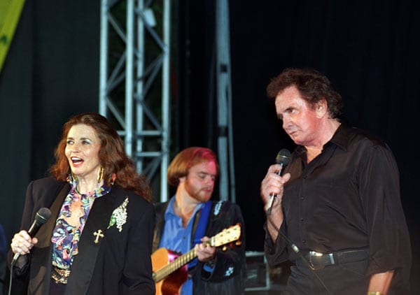 1994, als niemand mehr damit rechnet, gelingt Johnny Cash ein riesiges Comeback. Auch bei der jungen Generation gewinnt er neue Fans dazu. Das Bild zeigt die Country-Legende mit Ehefrau June Carter bei einem Auftritt am Kölner Tanzbrunnen am 7. Juli 1994.
