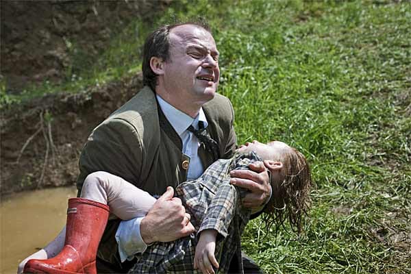 Katharinas Vater (Gerhard Liebmann) hält den leblosen Körper seiner Tochter in den Armen, nachdem er diesen aus dem Teich geborgen hat.