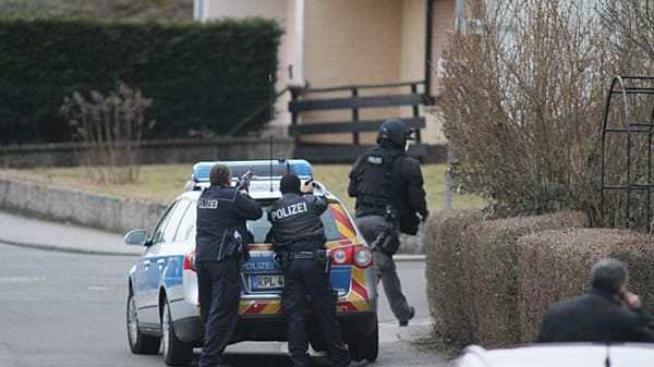 Polizisten umstellen das Haus des Todesschützen von Weilerbach